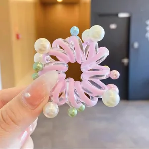Vista dettagliata dell'elastico per capelli a filo di telefono rosa con perle.