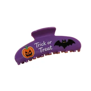 Détail de pince à cheveux d'Halloween violette avec des graphismes effrayants citrouille et chauve-souris.