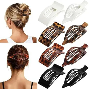 Detailed view of flat round hair clip set, showing tortoiseshell, white and black designs.