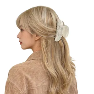 Close-up of elegant rhinestone acrylic hair claw clip worn on blonde hair, side view detail.