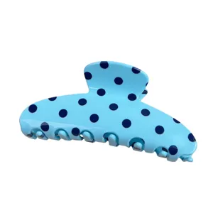 Close-up detail of the light blue hair claw clip featuring dark blue polka dots design.