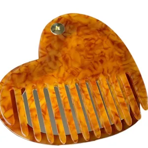 Dettaglio del pettine specchio in acetato tartarugato a forma di cuore, strumento per capelli.