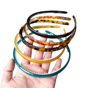 Vista dettagliata di cerchietti per capelli colorati in plastica con denti nella mano