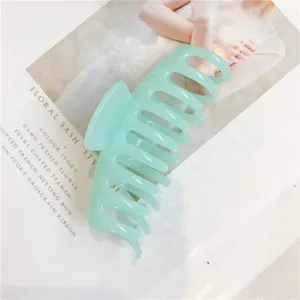 Close-up detail shot of a pastel green jelly hair claw clip showcasing its shark teeth design.
