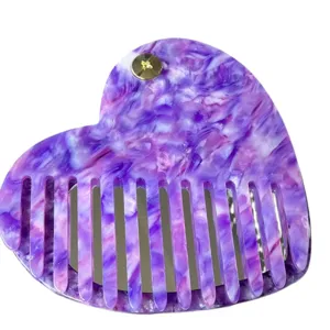 Primo piano del pettine per capelli in acetato viola marmorizzato a cuore con specchio.