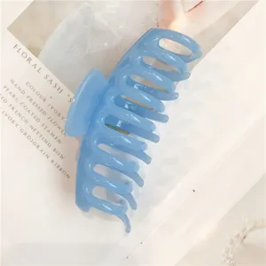Detail shot of a light blue jelly hair claw clip, translucent resin shark clip with smooth teeth.