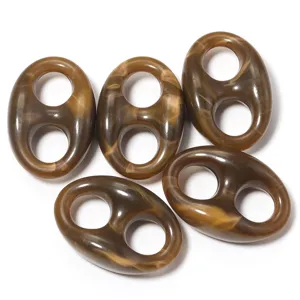 Acrylic marbled pig nose bead close up, brown tortoiseshell dual hole DIY jewelry detail view.