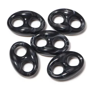 Detailed close-up of black marbled acrylic pig nose links, smooth glossy DIY jewelry beads.