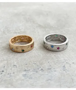 Vue détaillée de bagues en métal brossé de style italien serties de pierres zircones colorées.