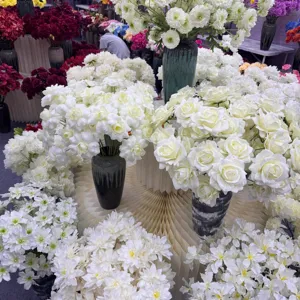Detailed view of white artificial chrysanthemum and rose flower arrangement for wedding and event decor.