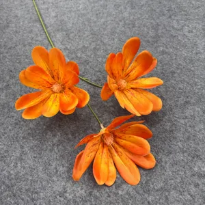 Dettaglio di fiori finti in seta arancione, decorazione floreale realistica per casa e matrimonio.