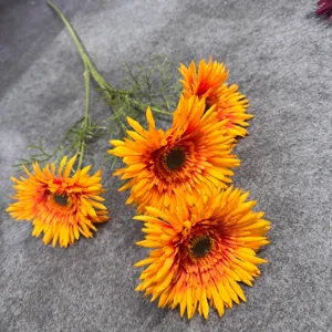 Detailed view of 4-head artificial gerbera daisy flowers with vivid orange petals.