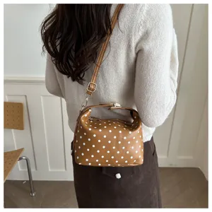 Detail view of the brown polka dot cosmetic handbag, showing premium texture and stylish design.