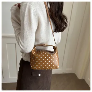 Detail shot of the brown polka dot cosmetic bag lifestyle view, showcasing stylish design and texture.
