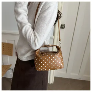 Brown polka dot cosmetic bag detail shot showing elegant design, portable strap and stylish look.