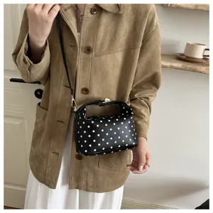 Black and white polka dot cosmetic bag with handle and strap, stylish daily handbag.