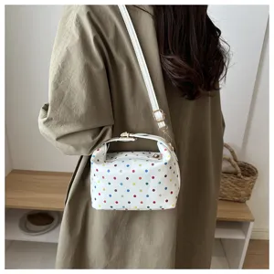 Detailed view of stylish white colorful polka dot cosmetic bag with handle and strap, chic wear.