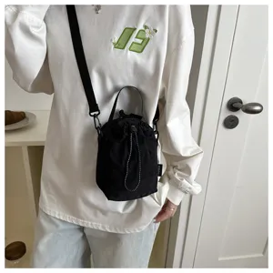 Vista dettagliata della borsa a secchiello nera in nylon con coulisse, borsa a tracolla casual.