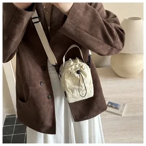 Scatto dettagliato di una borsa per borraccia con coulisse crema, elegante tracolla casual.