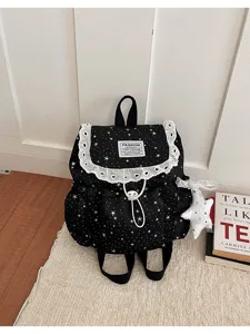 Détail de sac à dos étoile noire avec volants en dentelle blanche et cordon de serrage.