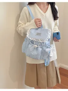 Détail du joli sac à dos bleu clair avec imprimé d'étoiles et bordure en dentelle.