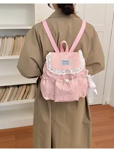 Vue détaillée du sac à dos rose à motif d'étoiles, bordure en dentelle blanche et bretelles.