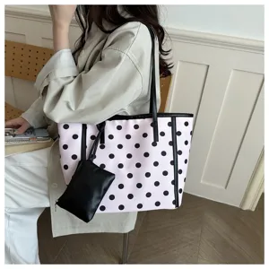 Elegante borsa shopper rosa a pois neri con manici neri e pochette vista dettagliata.