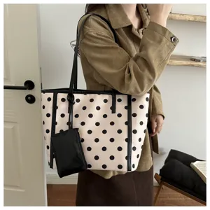 Vista dettagliata della borsa a tracolla beige a pois con piccola borsetta inclusa.