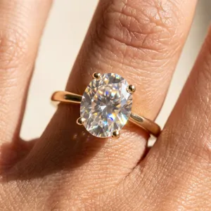 Gros plan détaillé de la bague solitaire en moissanite ovale avec anneau plaqué or.
