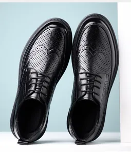 Gros plan détaillé de chaussures richelieu homme en cuir noir avec motif perforé élégant et respirant.