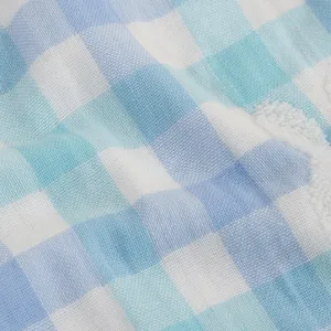 Close-up detail of soft cotton baby square towel with blue and white checkered pattern.