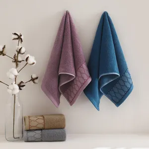 Soft cotton towel detail showcasing neat folded layers, rich texture, and geometric woven border.