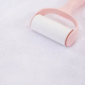 Detail view of pink lint roller cleaning white textured microfiber fabric surface carefully.