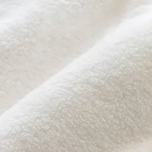 Soft white coral fleece hand towel fabric macro shot, highly absorbent and gentle material.