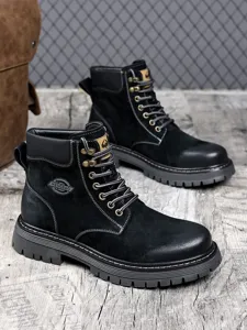 Detailed close-up shot of black high-top suede work boots with thick anti-slip rubber soles.