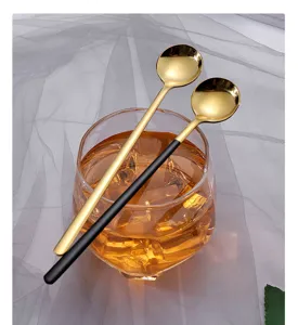 Cuillère mélangeuse à long manche en acier inoxydable, finition or et noir, idéale pour boissons.