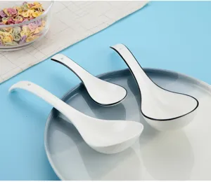 Vista detallada del juego de cucharas de sopa de cerámica blanca con borde negro elegante.