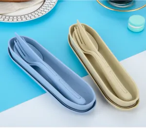 Detail view of portable wheat straw cutlery set in blue and beige boxes, fork, spoon, and knife.