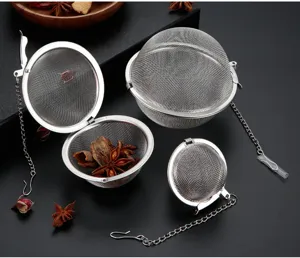 Primo piano di sfere per tè in rete di acciaio inossidabile con catene per infusione.