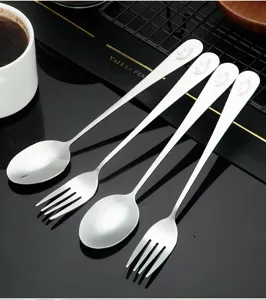 Ensemble de couverts en acier inoxydable avec design visage souriant, cuillère et fourchette.