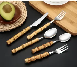 Stainless steel cutlery set with bamboo handles, including steak knife, forks, and spoons for table.