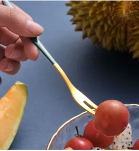 Dettaglio della forchetta per frutta in acciaio inossidabile con manico verde e due punte.