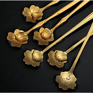 Detailed view of gold stainless steel sakura spoon, elegant long handle coffee stirrer for dessert.