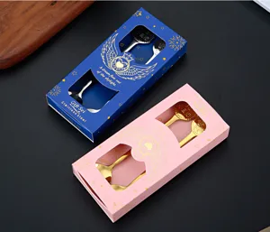 Vista detallada de cajas de regalo de cucharas de acero inoxidable en azul y rosa, mesa.