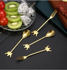 Detailed shot of gold crown cutlery, including dessert spoons and fruit forks on a table.