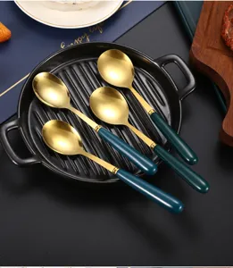Detail view of stainless steel ceramic soup spoons, dark green and gold design, 4pcs set.