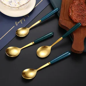 Stainless steel ceramic soup spoon with green gold handle for home dining and kitchen use.