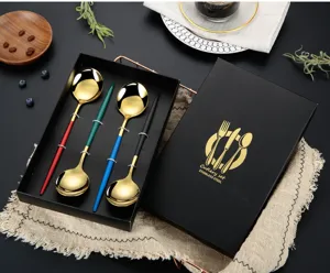 Detail view of the stainless steel cutlery set with colorful handles and golden spoons.