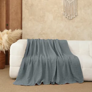 Solid grey gauze throw blanket detailed close-up shot showcasing soft textured fabric on sofa