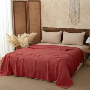 Detail of the soft cotton gauze blanket, cozy bedroom scene, breathable summer quilt texture.